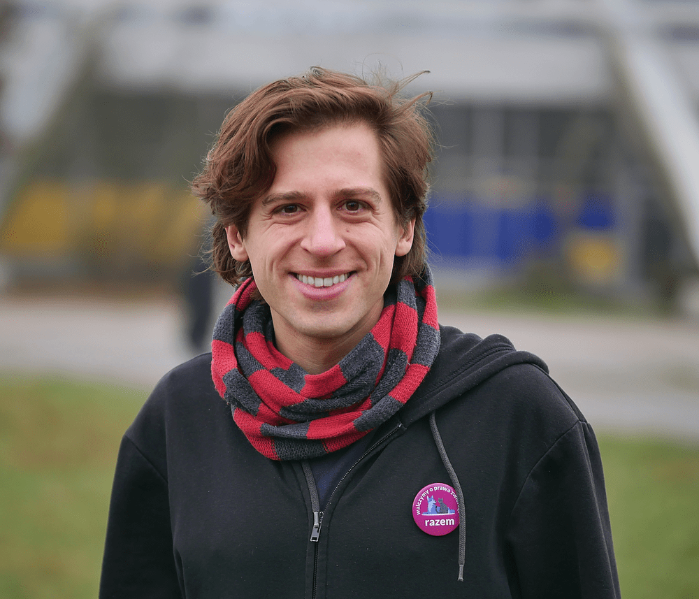 Mateusz Jarczyński z flagą partii Razem